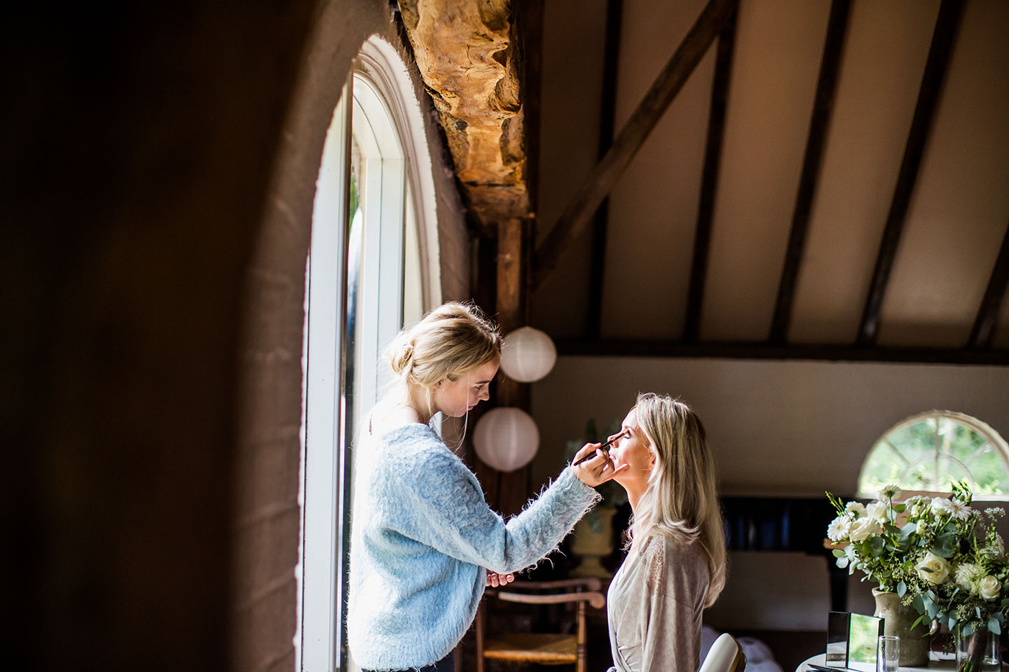 Bruid in de make-up tijdens bruiloft bij Kasteel Tongelaar