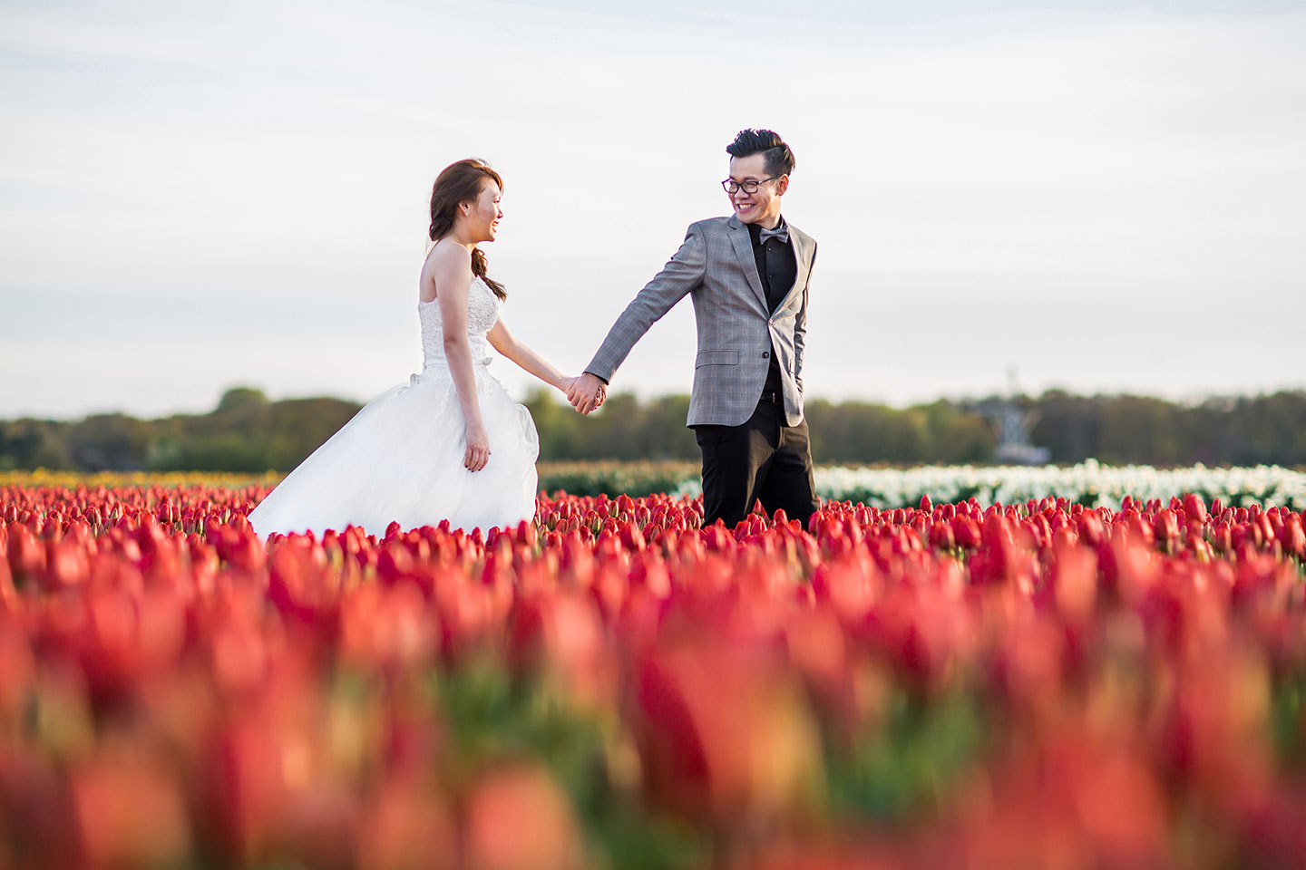 Pre wedding shoot Keukenhof couple strolling through fields of tulips