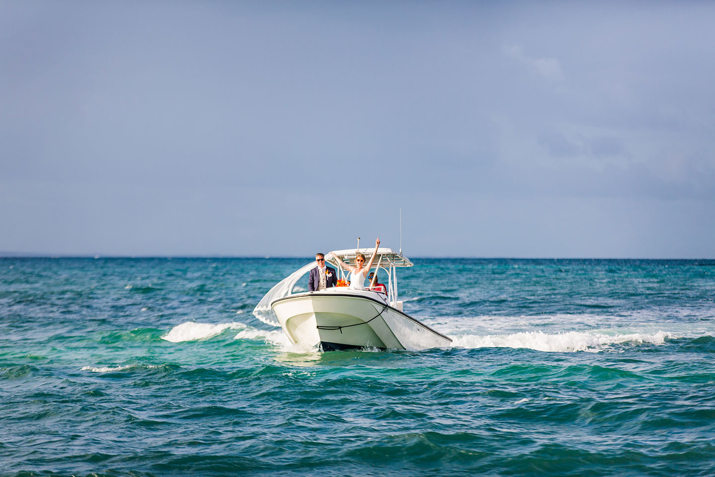 Couple arrives on a boat at their Caribbean wedding