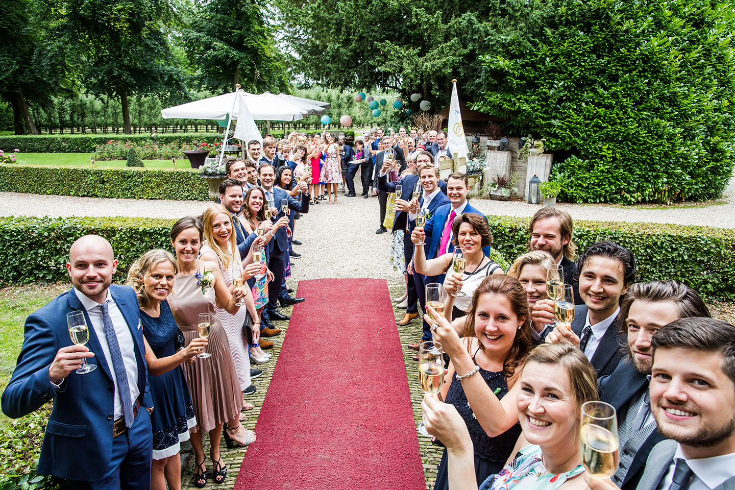 Bruidspaar wordt opgewacht door gasten tijdens bruiloft bij Kasteel Wijenburg