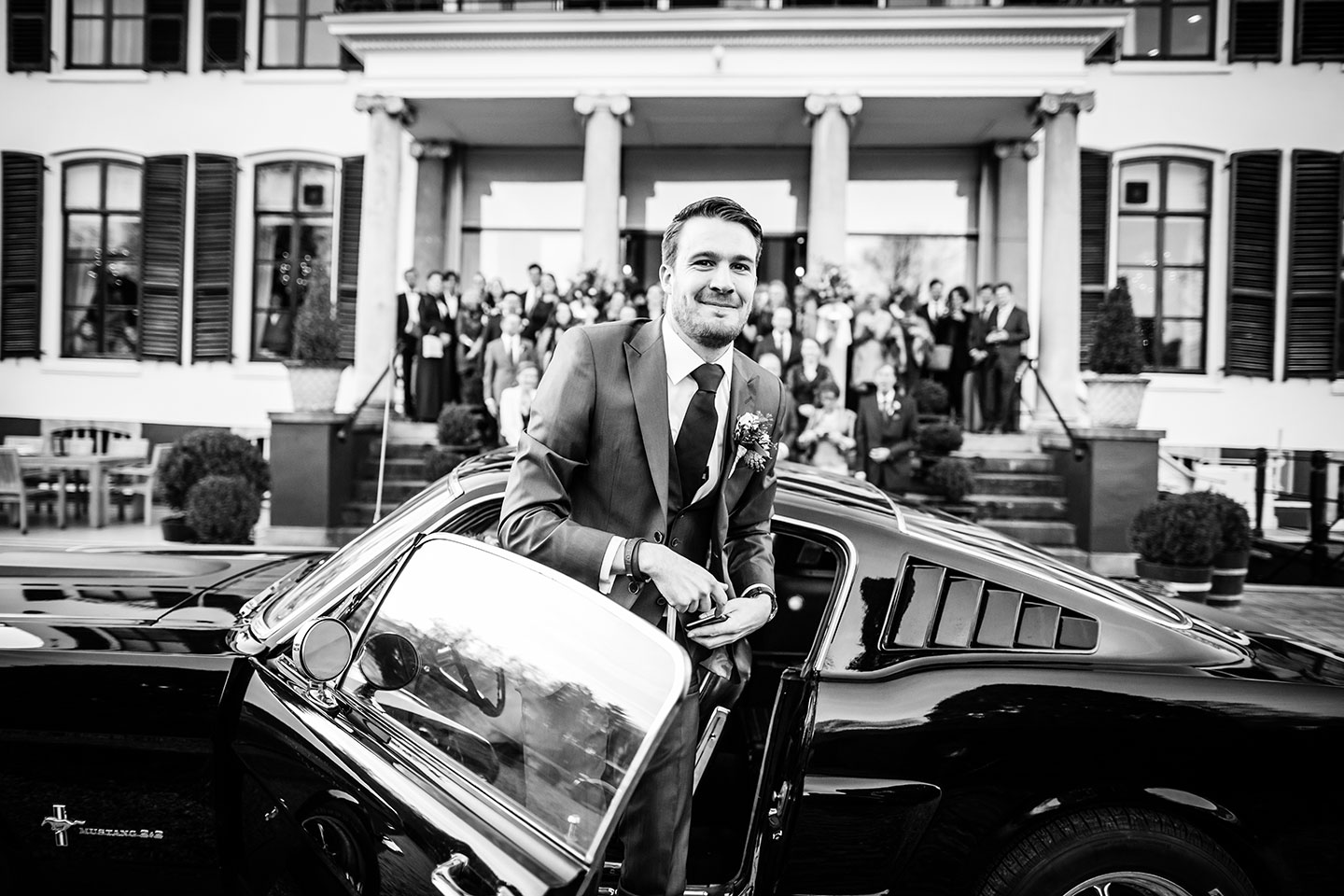 Bruidegom komt aan in zijn trouwauto bij Kasteel Engelenburg voor een bruiloft